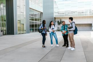 Four students outside a college building